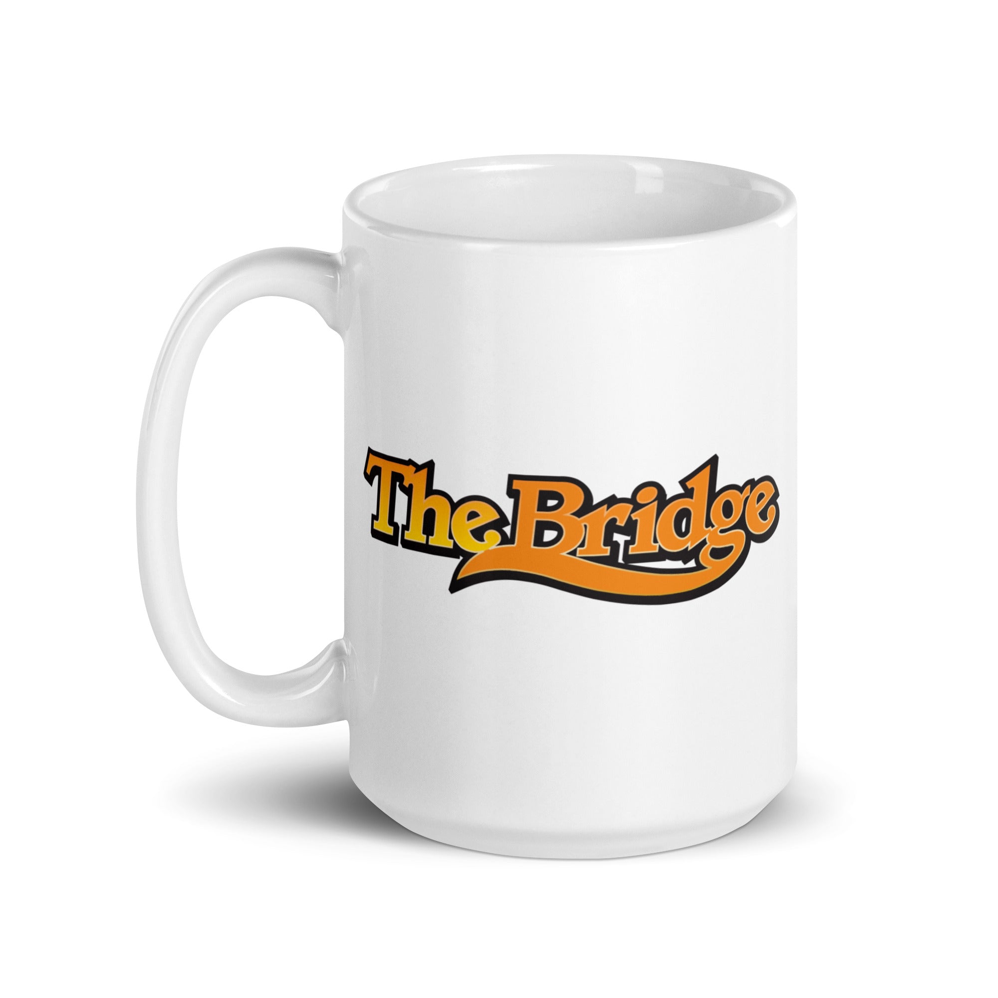White coffee mug featuring the text 'The Bridge' in bold orange and black letters.