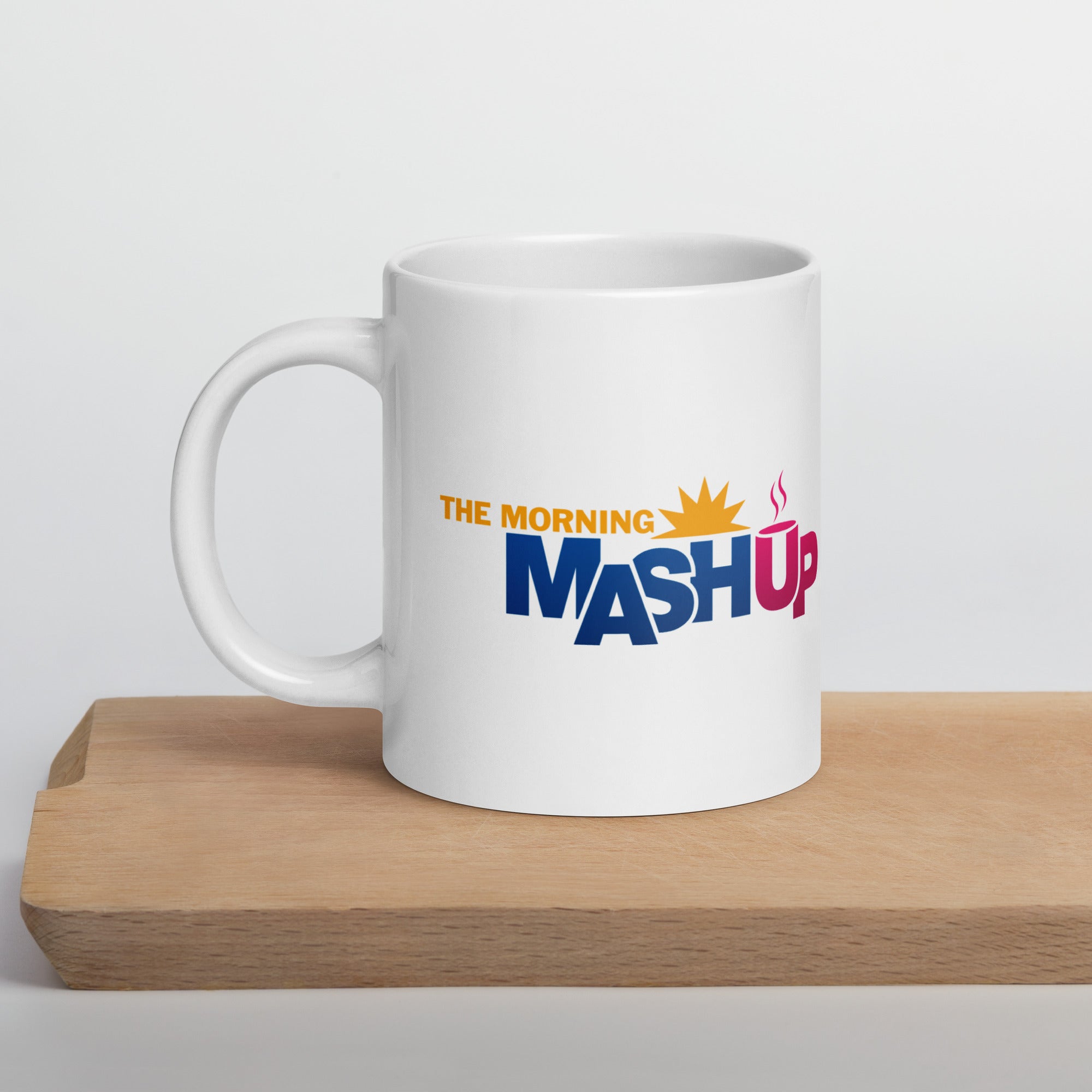 White mug with 'The Morning Mash Up' logo on a wooden surface