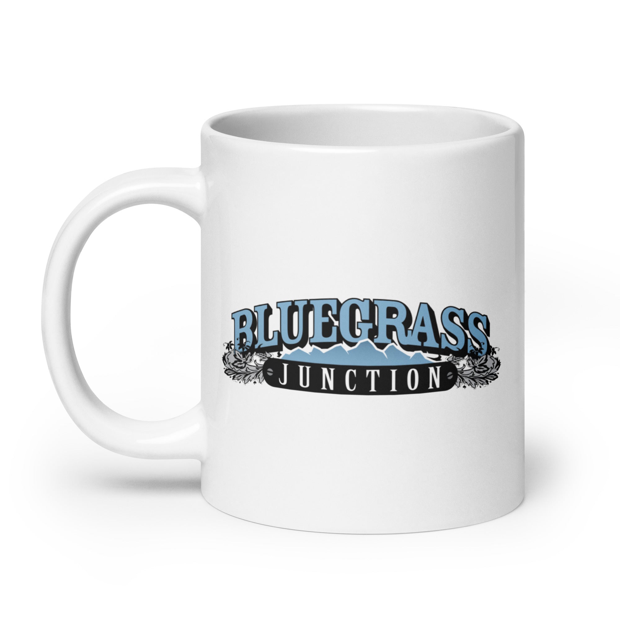 White mug with 'BLUEGRASS JUNCTION' in blue and black lettering, featuring mountain graphics and decorative elements.