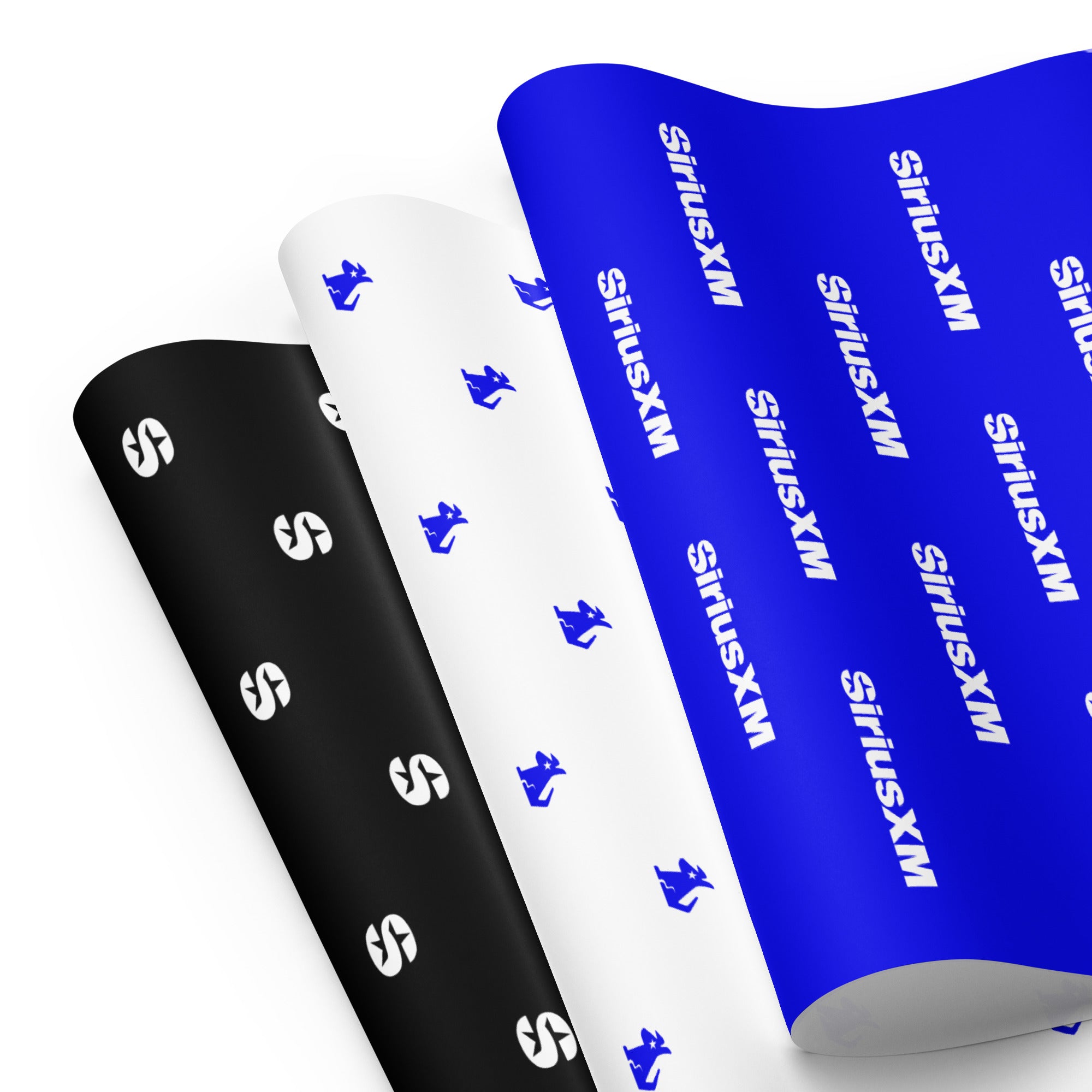 Three rolls of wrapping paper featuring "SiriusXM' and Stella dog logos in black, white, and blue patterns.