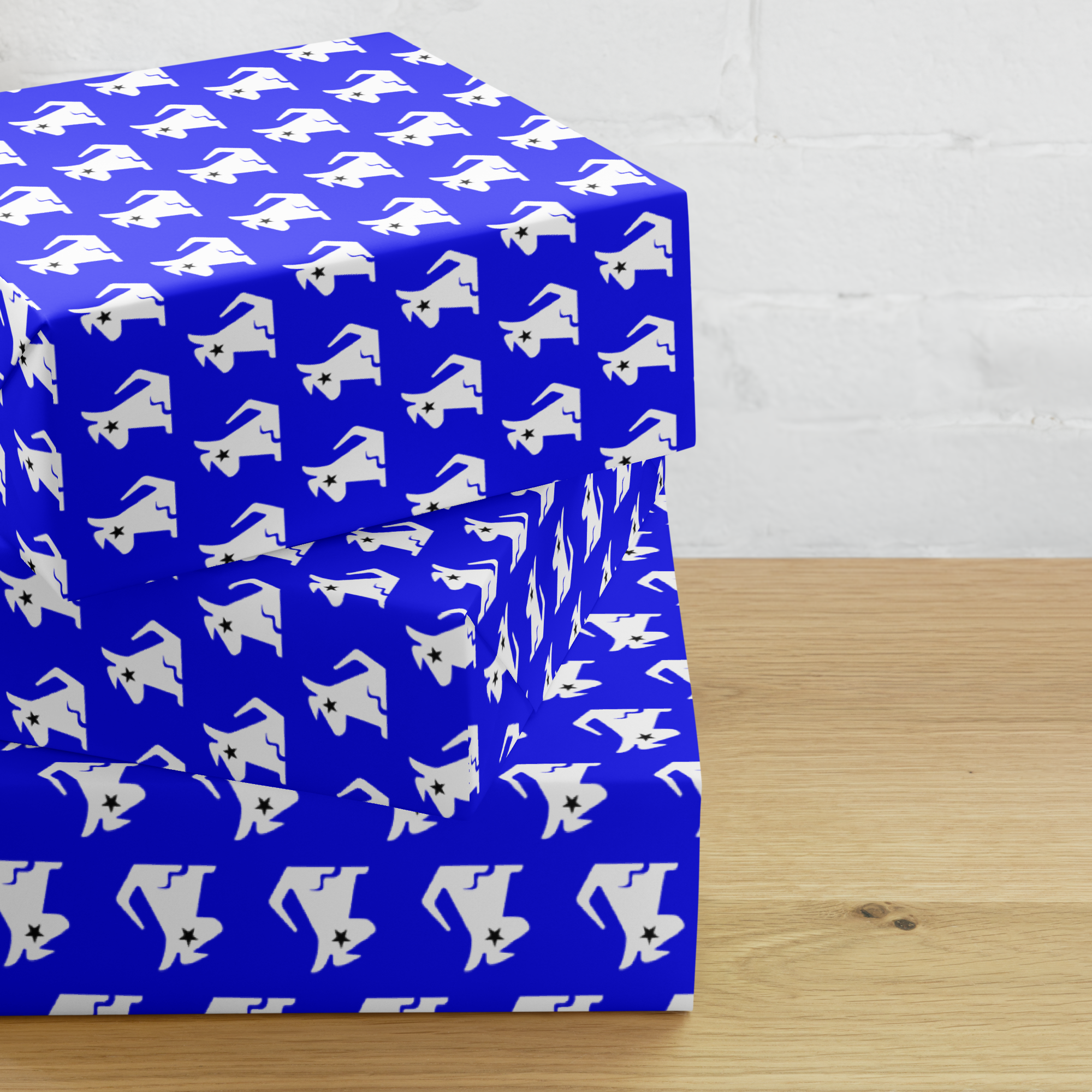 Blue gift boxes wrapped in 'Stella' patterned paper featuring white dog silhouettes, placed on a wooden surface.